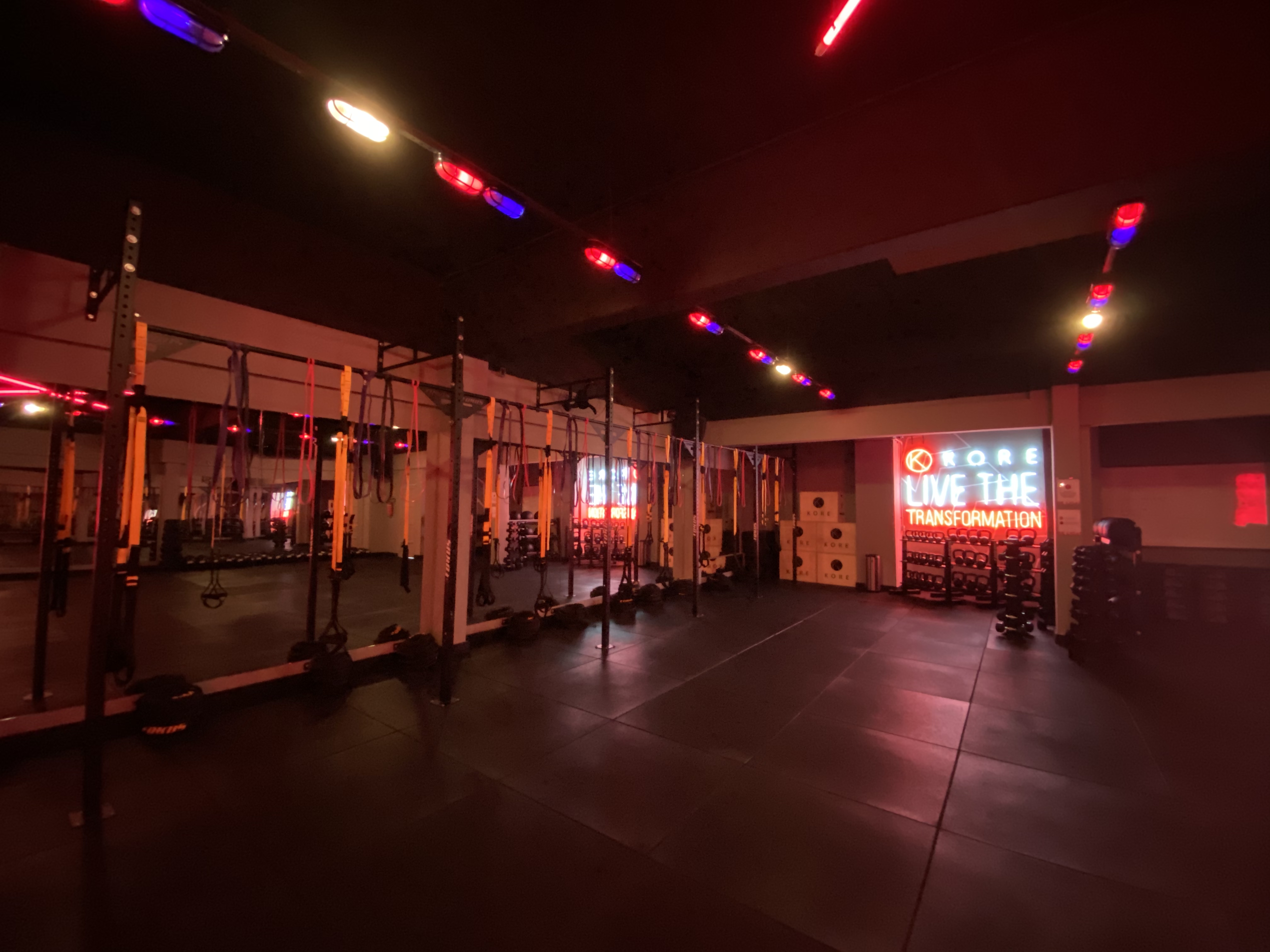 Academia KORE: sala de treino funcional com iluminação cênica em vermelho