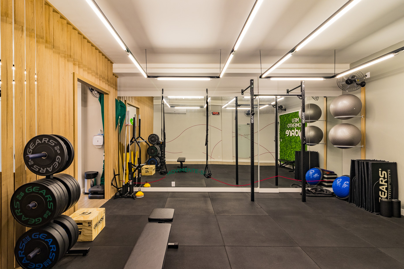 Box de treino funcional com ripado de madeira e iluminação linear